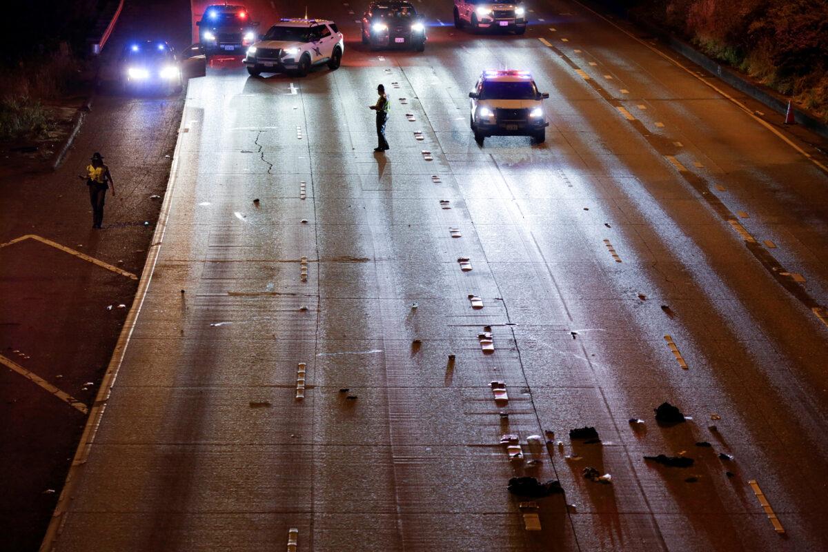 Washington state troopers investigate the scene where two people in a group of protesters were struck by a car on I-5 in Seattle, on July 4, 2020. (Jason Redmond/Reuters)