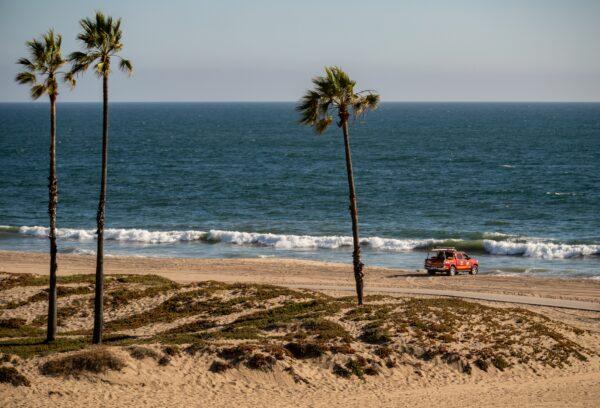 A lifeguard in Los Angeles patrols an empty beach in Playa Del Rey, Calif., on July 3, 2020. (John Fredricks/The Epoch Times)