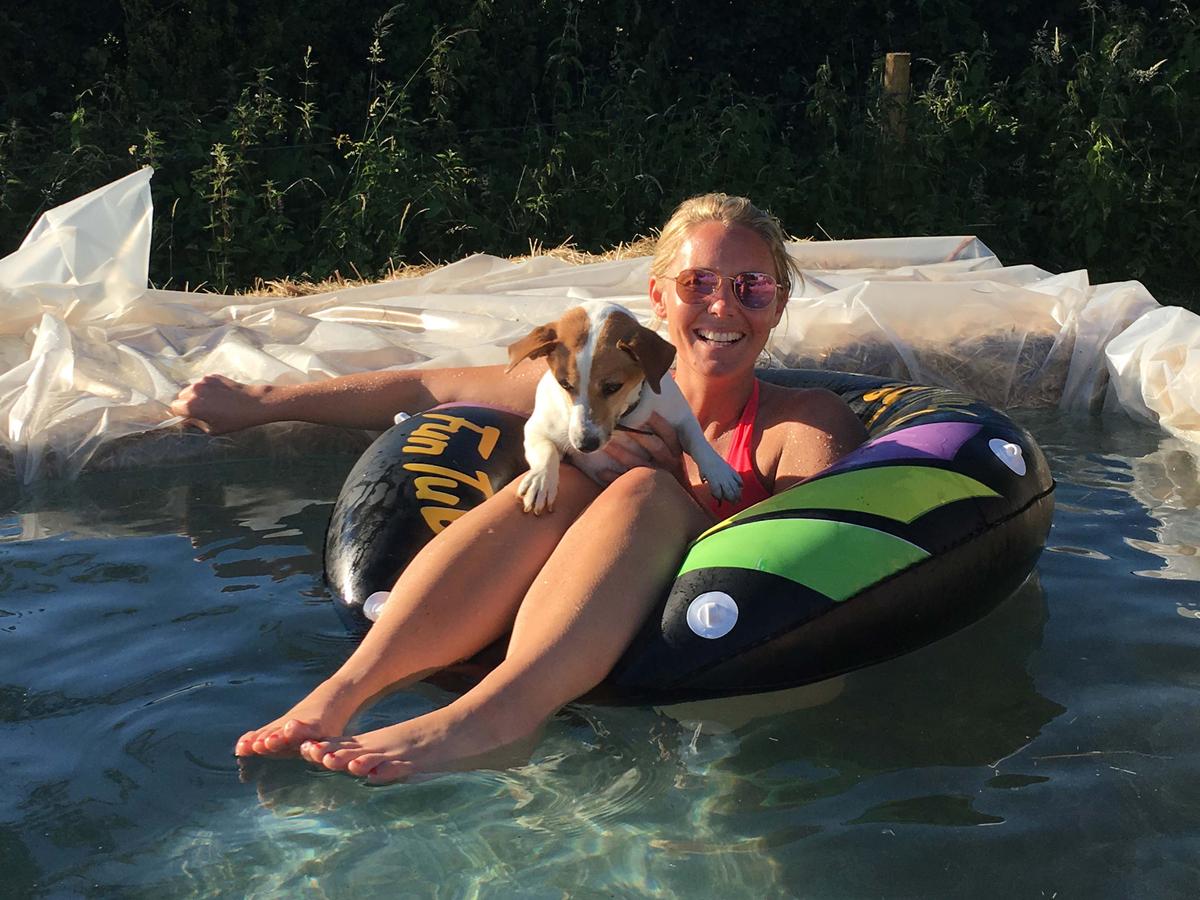 Friend Harriet and dog Muff enjoying the hay bale pool (Caters News)