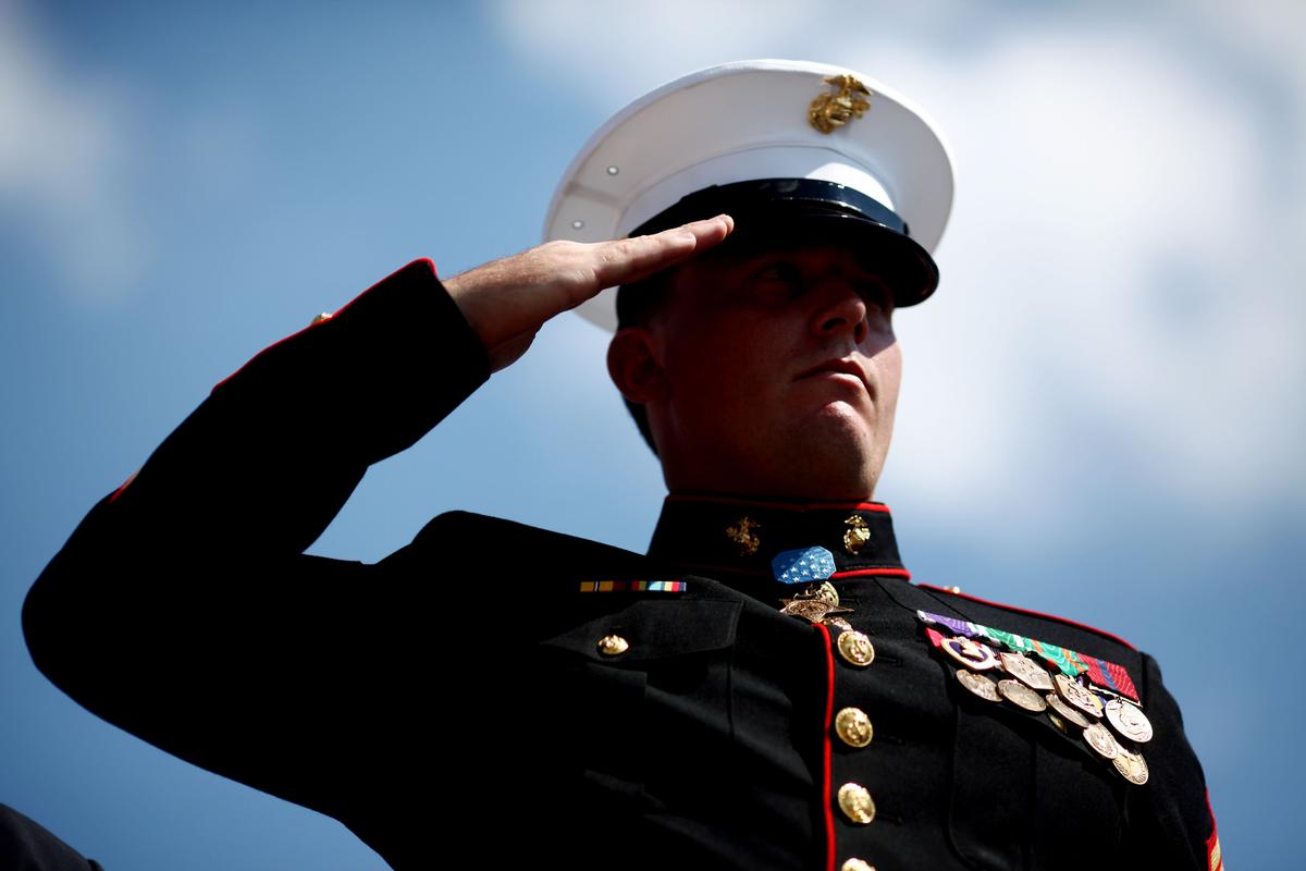Former active-duty Marine Corps Corporal and Medal of Honor recipient Dakota Meyer salutes during the playing of the national anthem in his hometown in Greensburg, Kentucky. (Luke Sharrett/Getty Images)