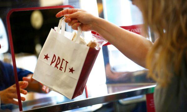 A bag is passed to a customer at Pret A Manger in New Cavendish Street, in London, on June 1, 2020. (Hannah McKay/Reuters)