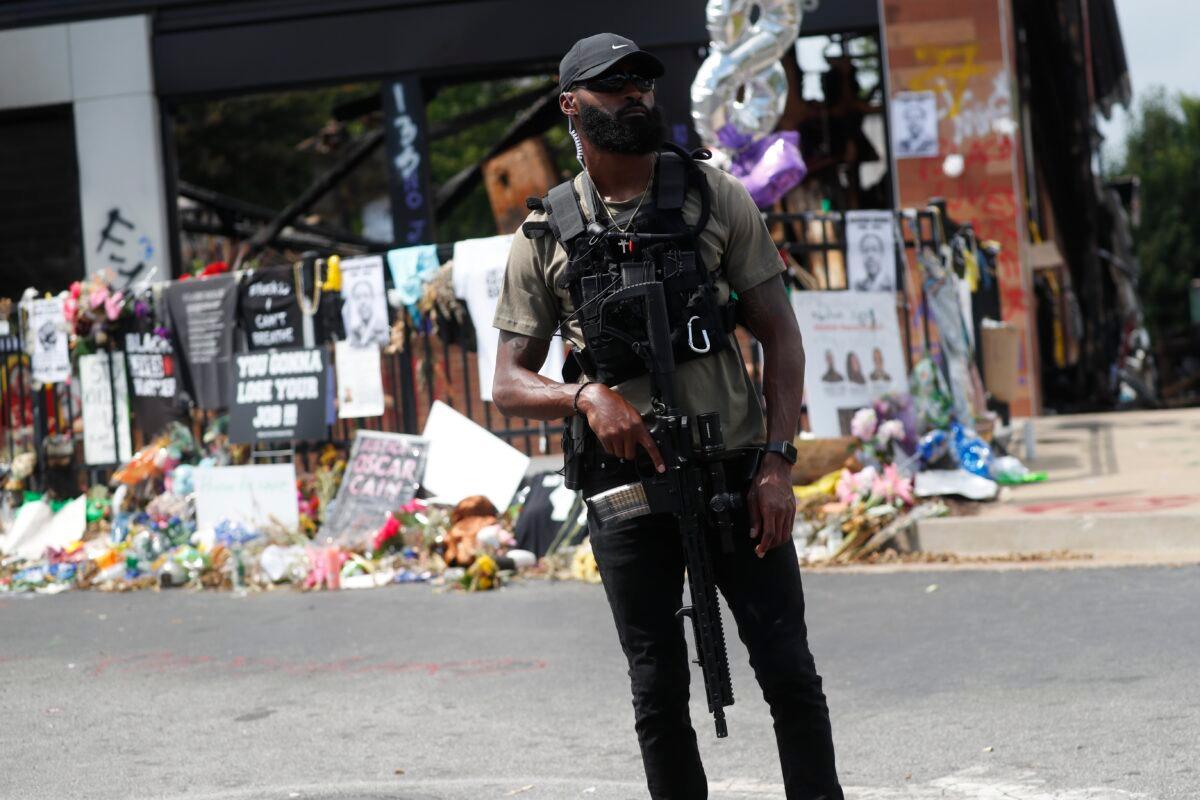  An armed man stands outside the Wendy's where Rayshard Brooks was shot, in Atlanta, Ga., on June 23, 2020. (John Bazemore/AP Photo)