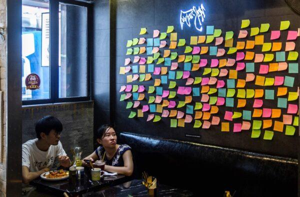 Customers sit near blank notes on a Lennon Wall inside a pro-democracy restaurant in Hong Kong on July 3, 2020, in response to a new national security law introduced in the city which makes political views, slogans, and signs advocating Hong Kong's independence or liberation illegal. (Isaac Lawrence/AFP via Getty Images)