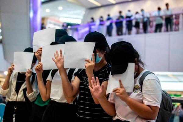 Protesters hold up blank papers during a demonstration in a mall in Hong Kong, in response to a new national security law introduced in the city which makes political views, slogans and signs advocating Hong Kongs independence or liberation illegal, Hong Kong, on July 6, 2020. (Isaac Lawrence/AFP via Getty Images)