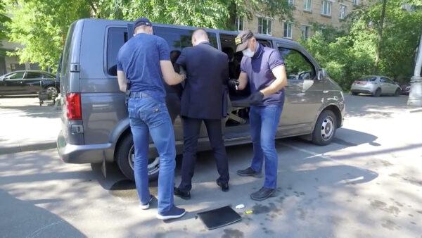 Ivan Safronov, a former journalist who works as an aide to the head of Russia's space agency Roscosmos, stands in front of a car while being detained by members of Russia's Federal Security Service (FSB) on state treason charges in Moscow, Russia, in this still image taken from video released July 7, 2020. (The Federal Security Service of the Russian Federation/Handout via Reuters)