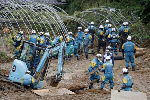 Police officers search missing people at the site of a landslide caused by heavy rain in Tsunagi town, Kumamoto prefecture, southern Japan, on July 7, 2020. (Kyodo/Reuters)