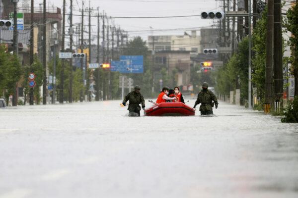 Local residents are rescued by Japan Self-Defense Force soldiers using a rubber boat on a flooded road, caused by heavy rain in Omuta, Fukuoka prefecture, southern Japan, on July 7, 2020. (Kyodo/Reuters)