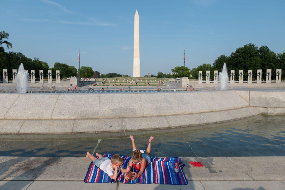 Two children wait near their parents for the beginning of fireworks near the Washington Monument on July 4, 2020. (Roberto Schmidt/AFP via Getty Images)
