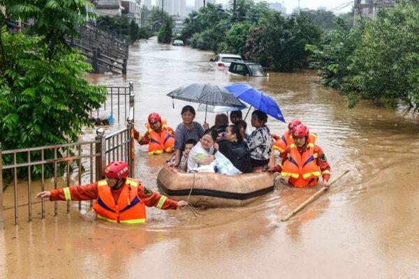 Rescuers evacuate flood-affected residents following heavy rain in Jiujiang in China's central Jiangxi Province on July 8, 2020. (STR/AFP via Getty Images)