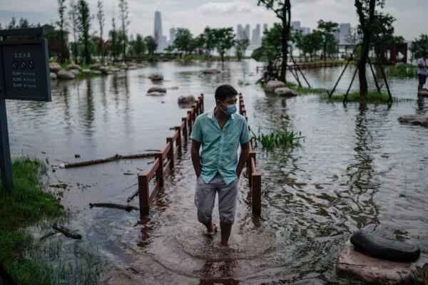 A resident wears a mask while walking through Jiangtan Park, which flooded due to heavy rains along the Yangtze River in Wuhan, China, on July 8th, 2020. (Getty Images)