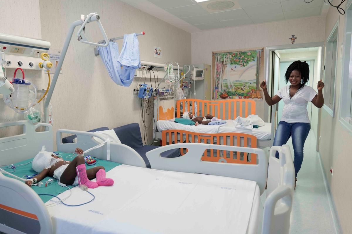 Ermine, right, looks at her twins, Ervina and Prefina, lying on their beds at the Bambino Gesu' Vatican pediatric hospital, in Rome, Tuesday, June 16, 2020. (Bambino Gesu Hospital via AP)