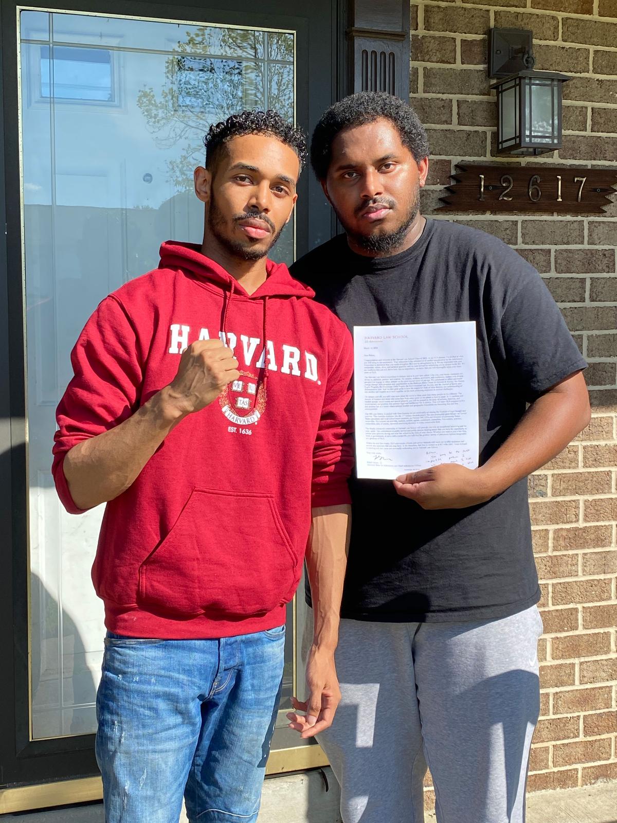 Rehan Staton with his older brother, Reggie Staton, holding his acceptance letter to Harvard Law School. (Courtesy of Rehan Staton)