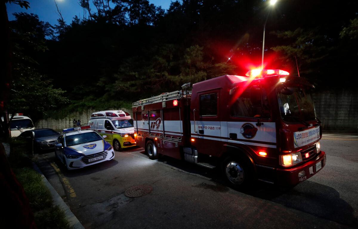 Fire, ambulance, and police vehicles are seen in front of a park in Seoul, South Korea, on July 9, 2020. (Lee Jin-man/AP Photo)