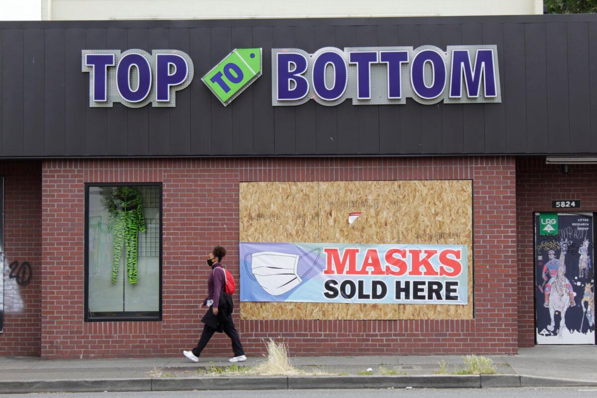 A pedestrian walks past a business damaged during recent riots, in Portland, Ore., on July 1, 2020. (Gillian Flaccus/AP Photo)