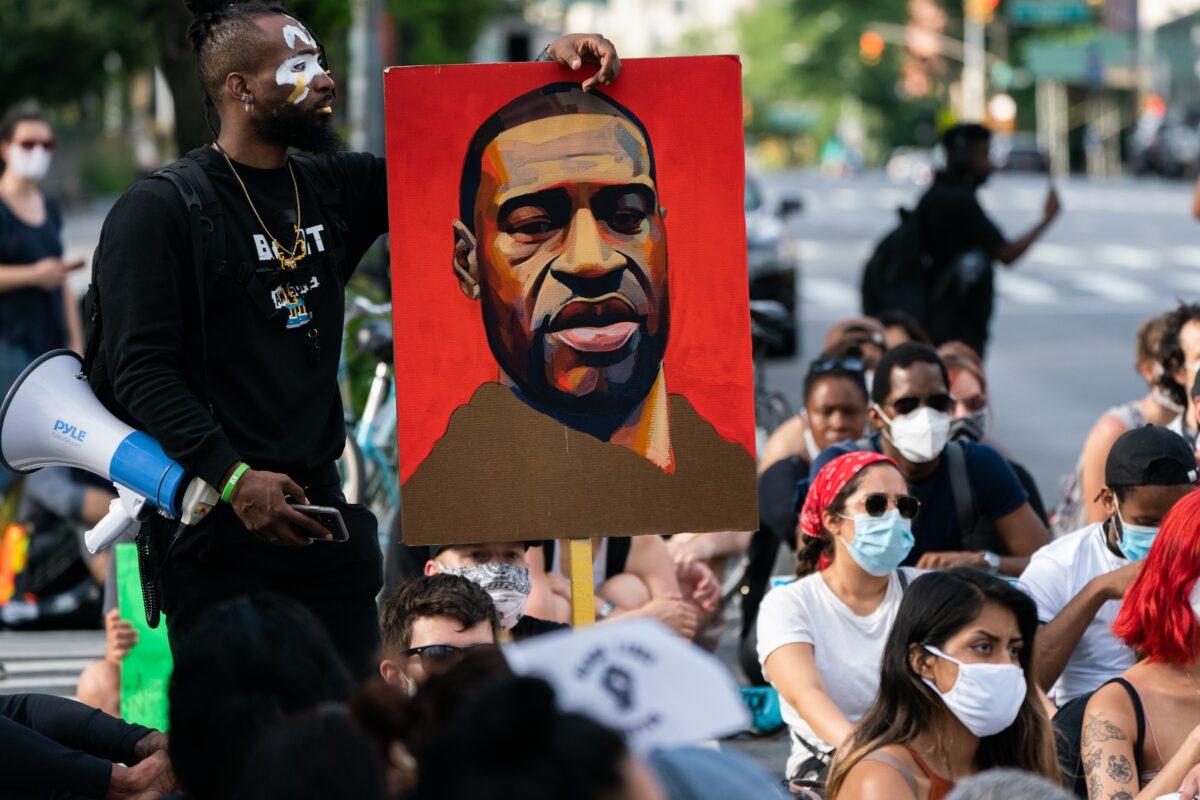 A man holds a picture of George Floyd during a Black Lives Matter protest in New York City on June 18, 2020. (Jeenah Moon/Getty Images)