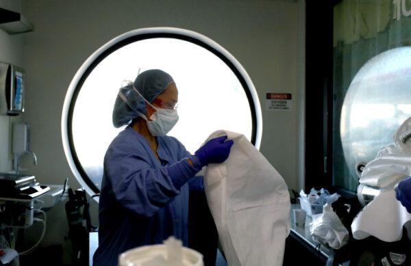 A nurse cleans personal protective equipment (PPE) after being part of a team that performed a procedure on a COVID-19 patient at Regional Medical Center in San Jose, Calif., on May 21, 2020. (Justin Sullivan/Getty Images)