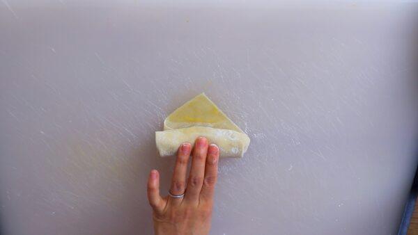Brush beaten egg over the top corner, then roll it up all the way, pressing tightly to seal. (Photo by CiCi Li)