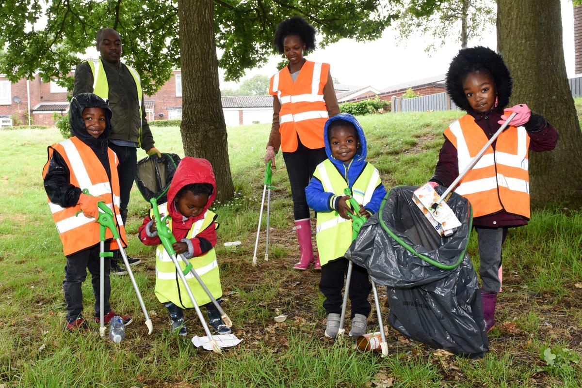 Simone and Mark Roberts pick up litter with their children. (Caters News)