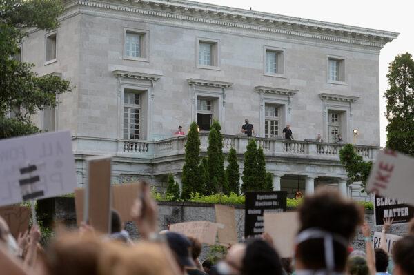 Security personnel stand on the balcony the home of Mark and Patricia McCloskey as protesters gather outside their neighborhood in St Louis, Missouri, on July 3, 2020. (Michael B. Thomas/Getty Images)