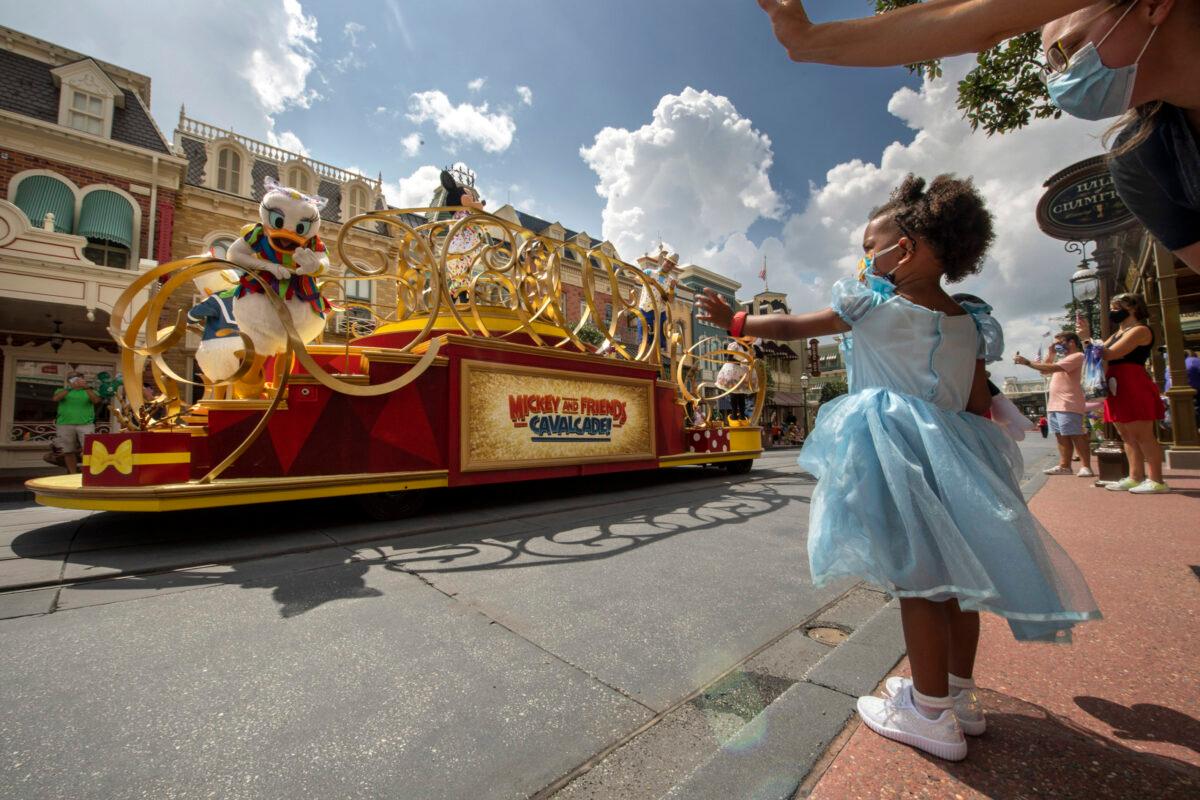 Guests wave as the Mickey and Friends Cavalcade passes by on Main Street, U.S.A. at Magic Kingdom Park, July 11, 2020, at Walt Disney World Resort in Lake Buena Vista, Fla. (Kent Phillips/Walt Disney World)