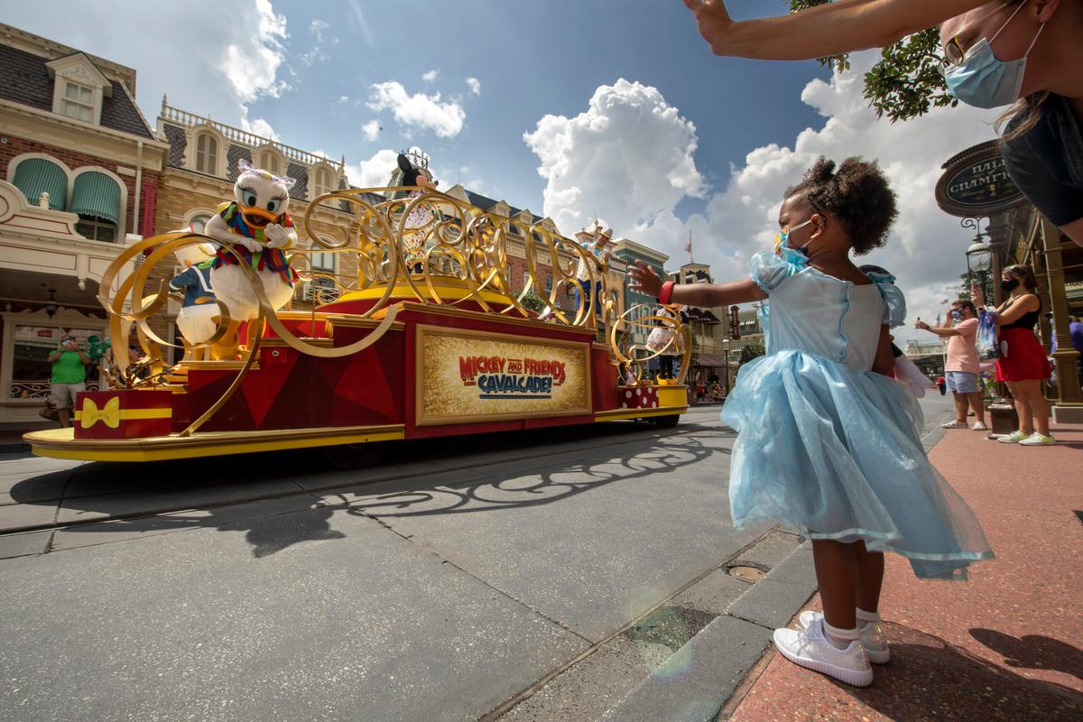 Guests wave as the Mickey and Friends Cavalcade passes by on Main Street, U.S.A. at Magic Kingdom Park, July 11, 2020, at Walt Disney World Resort in Lake Buena Vista, Fla., on the first day of the theme park’s phased reopening. (Kent Phillips/Walt Disney World)