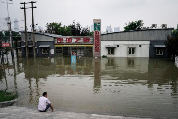 A resident sits by the flooded Jiangtan park along the Yangtze river in Wuhan, China, on July 10, 2020. (Getty Images)