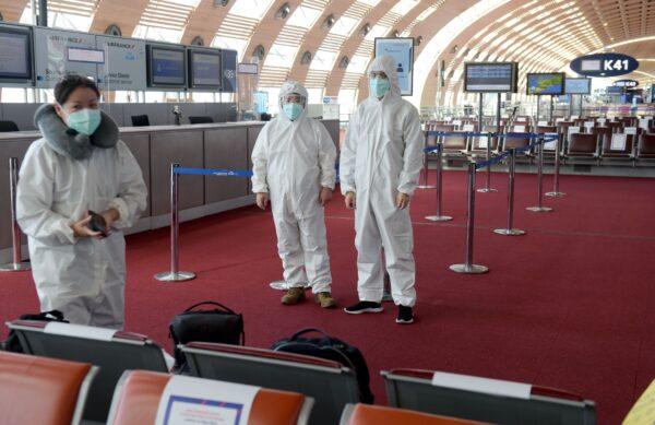 Passengers wearing protective clothing, at Charles de Gaulle Airport in Paris prior to boarding a China Southern Airlines flight to Guangzhou on May 12, 2020. (Eric Piermont / AFP via Getty Images)