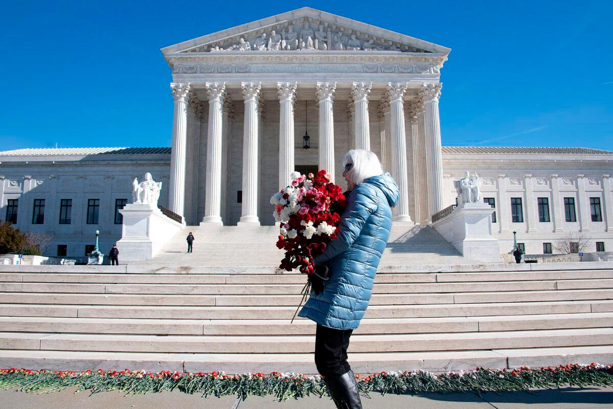 A woman helps lay 3,000 carnations to represent the approximately 3,000 abortions that occur in the United States every day, on the 46th anniversary of the Roe v. Wade decision, in front of the U.S. Supreme Court in Washington on Jan. 22, 2019. (Jim Watson/AFP via Getty Images)