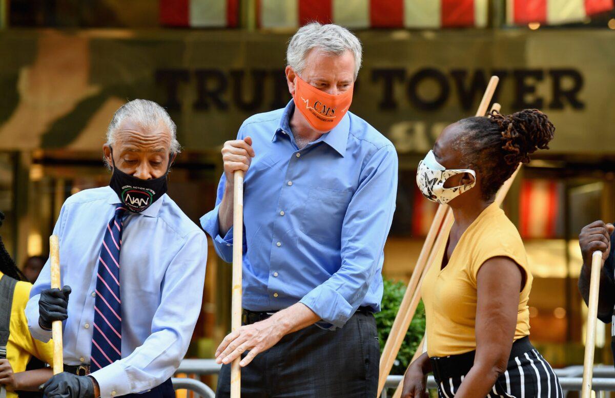 Rev. Al Sharpton, New York Mayor Bill de Blasio, and the mayor's wife Chirlane McCray, paint a new Black Lives Matter mural outside of Trump Tower on Fifth Avenue in New York City on July 9, 2020. (Angela Weiss/AFP via Getty Images)