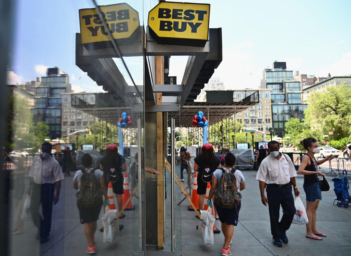 People wearing face masks walk past a Best Buy store near Union Square in New York on June 25, 2020. (Angela Weiss/AFP via Getty Images)