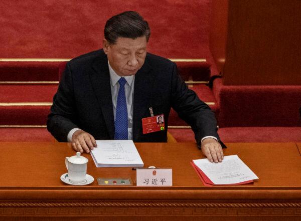 Chinese leader Xi Jinping arranges his papers at the closing session of the regime’s rubber-stamp legislature in Beijing, on May 28, 2020. (Kevin Frayer/Getty Images)