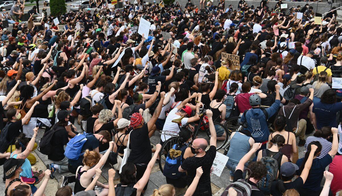 Protesters take a knee and raise their fists during a "Black Lives Matter" demonstration in front of the Brooklyn Library and Grand Army Plaza in Brooklyn, New York, on June 5, 2020. (Angela Weiss/AFP via Getty Images)