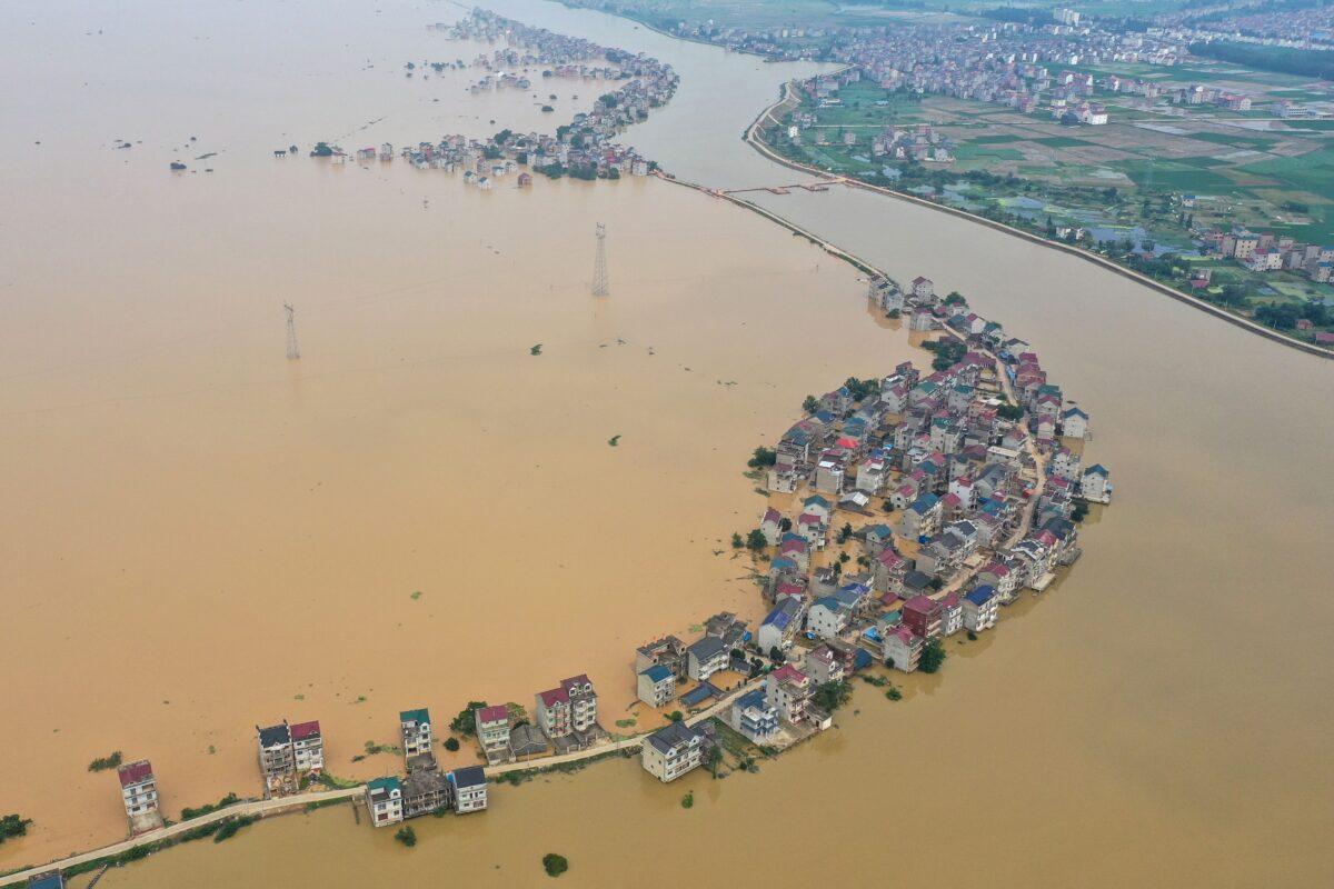 This aerial view shows submerged streets and inundated buildings after a dam was breached due to flooding in Jiujiang, China, on July 13, 2020. (STR/AFP via Getty Images)
