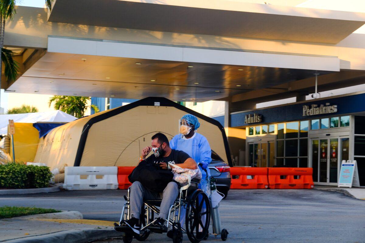 A nurse takes a patient to their car from Memorial West Hospital where COVID-19 patients are treated, in Pembroke Pines, Fla., on July 13, 2020. (Maria Alejandra Cardona/Reuters)
