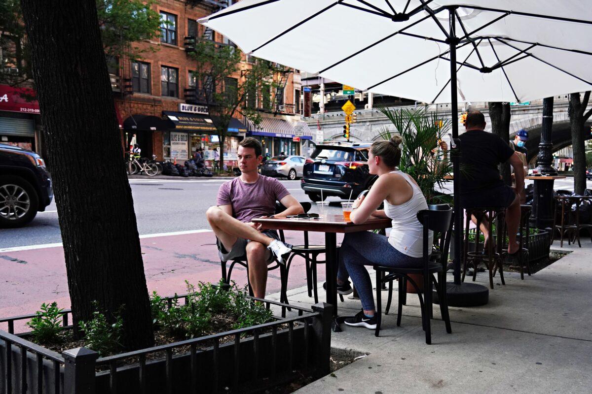 Two people sit in a temporary outdoor dining area as New York City moves into Phase 3 of re-opening, on July 13, 2020. (Cindy Ord/Getty Images)