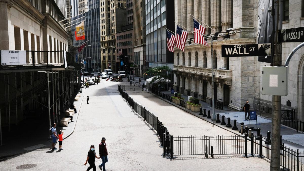 People walk by the New York Stock Exchange (NYSE) in an empty Financial District in New York City on June 15, 2020. (Spencer Platt/Getty Images)