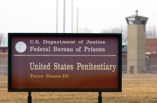 A guard tower flanks the sign at the entrance to the U.S. Penitentiary in Terre Haute, Ind., on March 17, 2003. (AP Photo/Michael Conroy File)