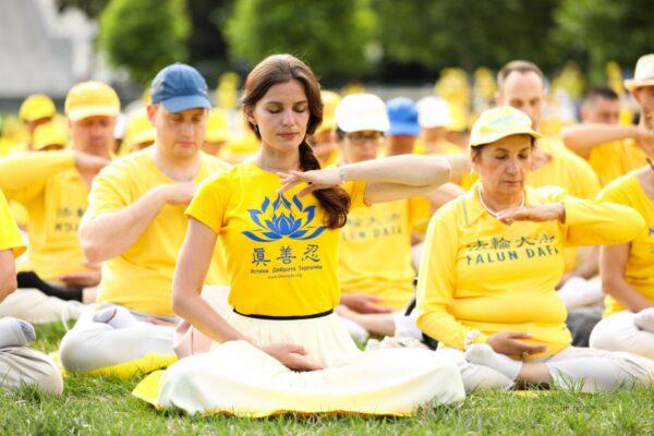 Falun Gong practitioners meditate during a demonstration to raise awareness about the Chinese Communist Party's persecution of the spiritual discipline, on the West Lawn of the U.S. Capitol in Washington on June 20, 2018. (Samira Bouaou/The Epoch Times)