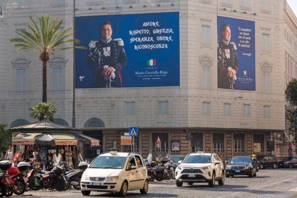 Posters portraying the Italian Carabinieri paramilitary police officer Mario Cerciello Rega, are displayed in the square where he was stabbed to death last year in Rome, Italy, on July 14, 2020. (Domenico Stinellis/AP Photo)