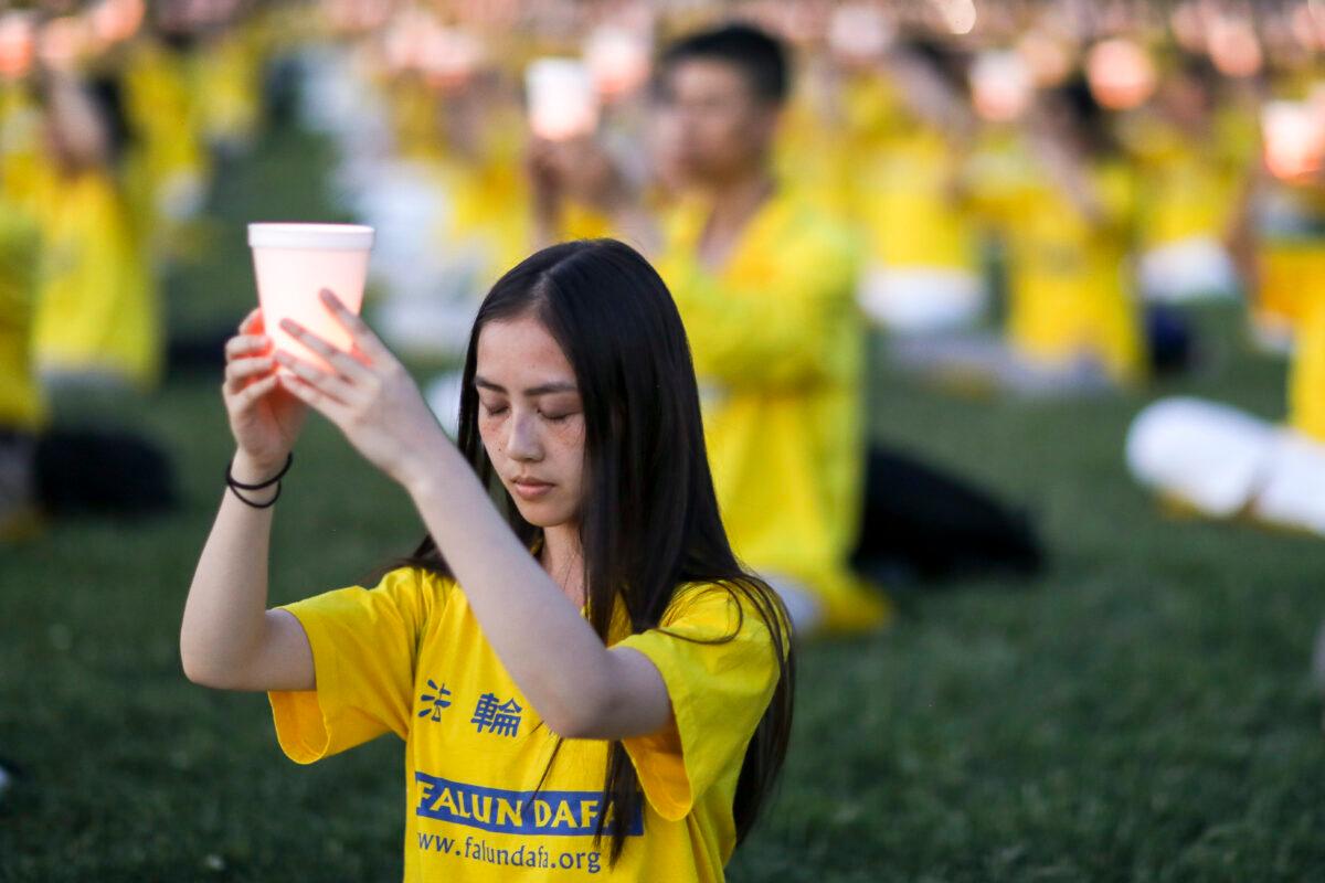  Falun Gong practitioners take part in a candlelight vigil commemorating the 20th anniversary of the persecution of Falun Gong in China, on the West Lawn of Capitol Hill on July 18, 2019. (Samira Bouaou/The Epoch Times)