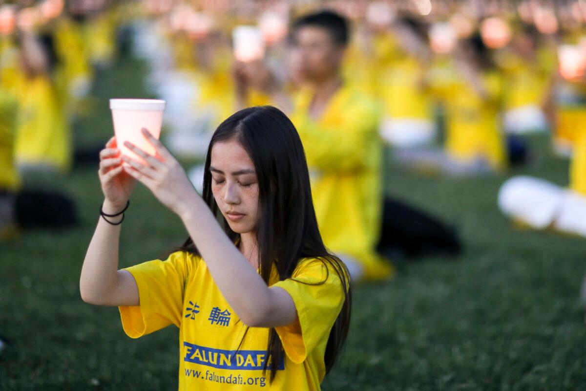 Falun Gong practitioners take part in a candlelight vigil commemorating the 20th anniversary of the persecution of Falun Gong in China, on the West Lawn of Capitol Hill on July 18, 2019. (Samira Bouaou/The Epoch Times)