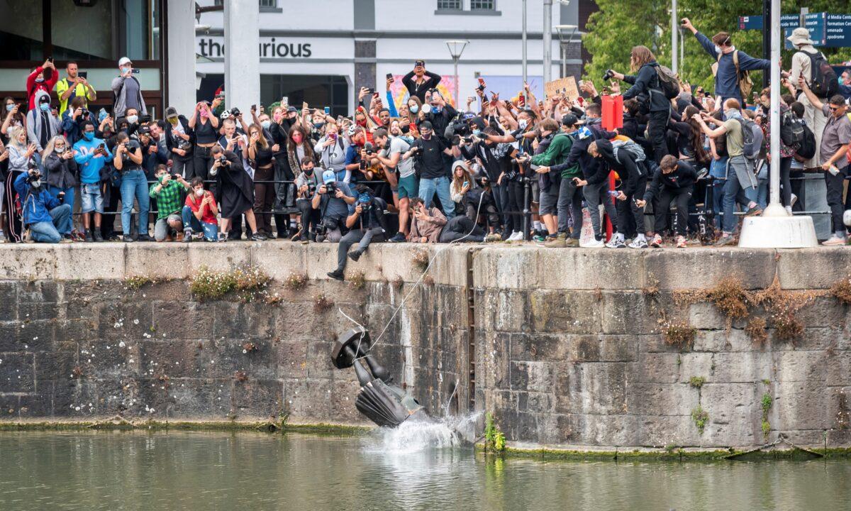 The statue of 17th century merchant, Edward Colston, falls into the water after protesters pulled it down during a protest following the death in Minneapolis police custody of George Floyd, in Bristol, England, on June 7, 2020. (Keir Gravil via Reuters)