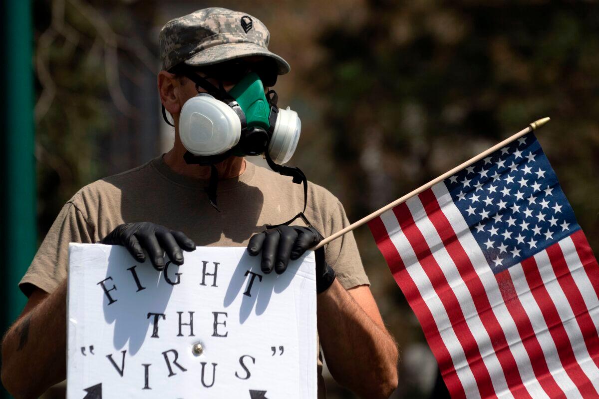 A demonstrator wears a respirator at a rally in Denver, Colo., on April 19, 2020. (Jason Connolly/AFP/Getty Images)