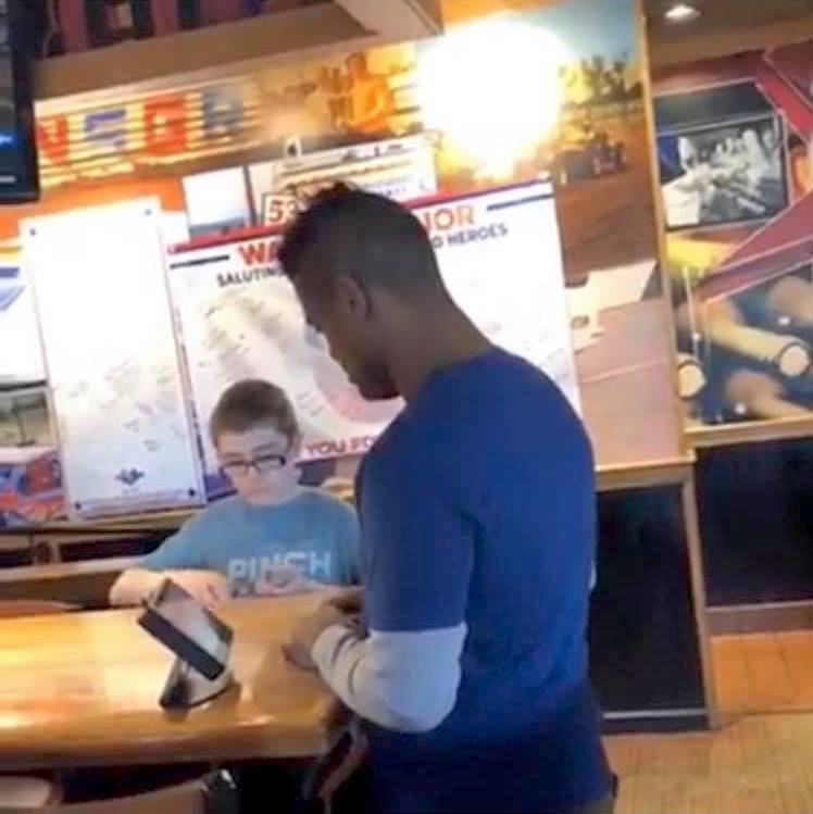 Colin and Kahlief demonstrating card tricks at Applebee’s. (Courtesy of <a href="https://www.facebook.com/megan.griffinhaas">Megan Griffin Haas</a>)