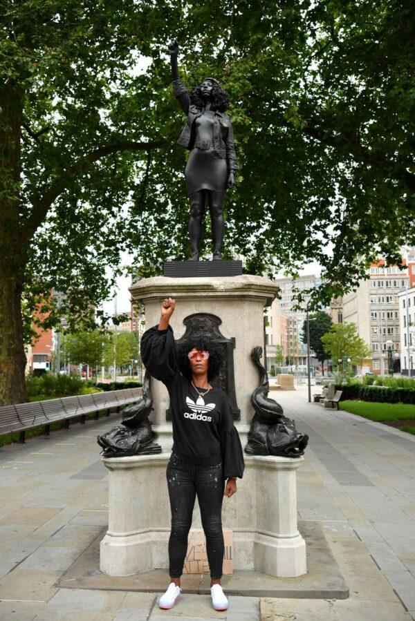 Black lives matter protester Jen Reid poses for a photograph in front of a sculpture of herself, by local artist Marc Quinn, on the plinth where the Edward Colston statue used to stand, in Bristol, England, on July 15, 2020. (Matthew Horwood/Getty Images)