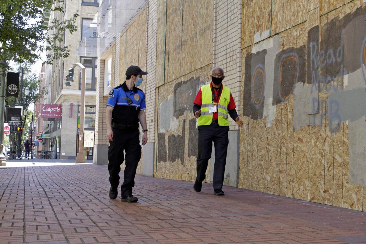 Two security officers walk in downtown Portland, Ore., on July 13, 2020. (Gillian Flaccus/AP Photo)