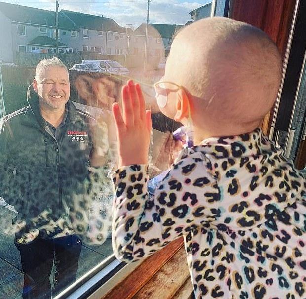  Mila giving a kiss to her dad through the glass. (Caters News)