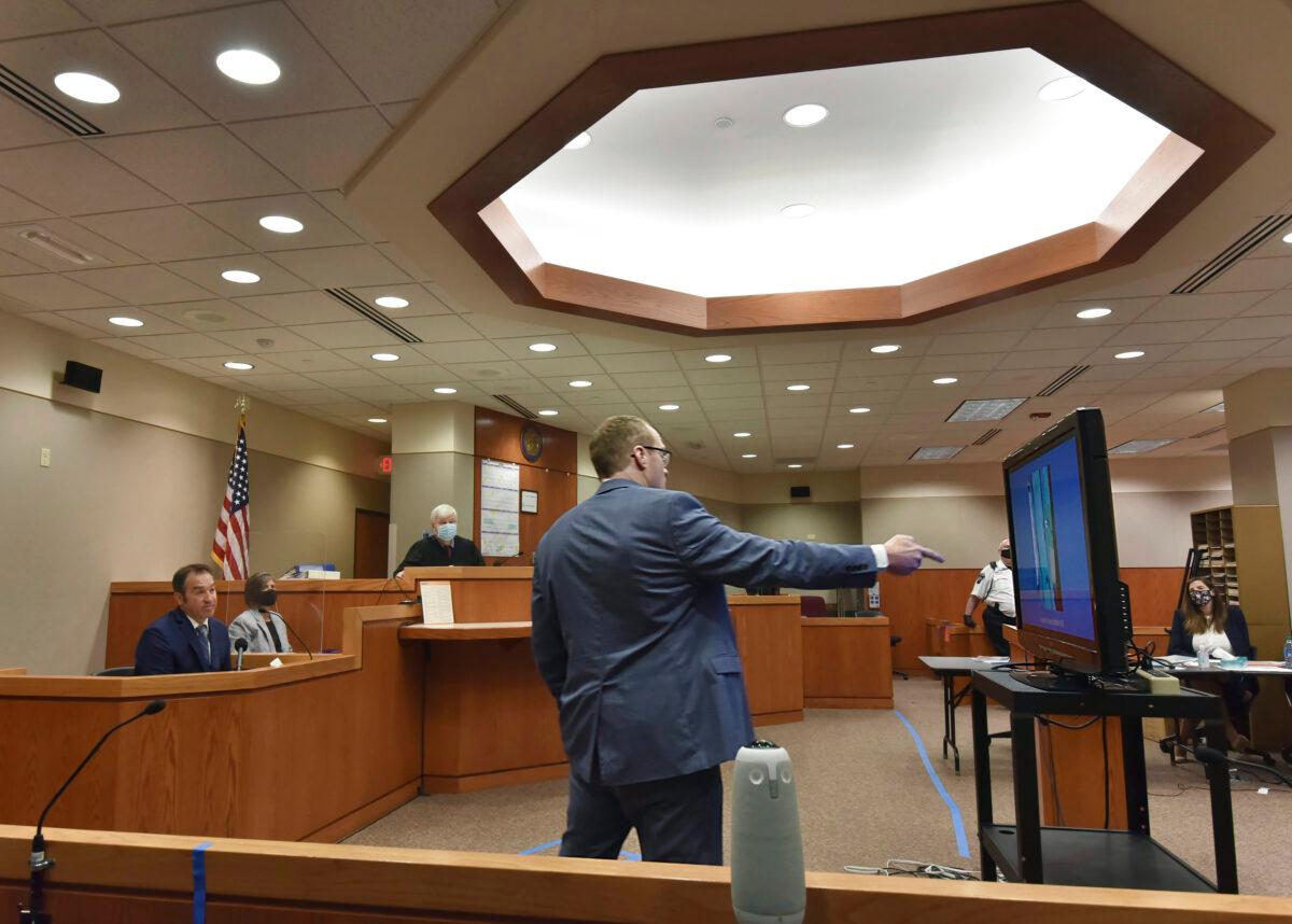 McHenry County State's Attorney Patrick Kenneally points to photographs on a flat screen as Crystal Lake Police Officer Brian Burr testifies in JoAnn Cunningham's sentencing hearing in Woodstock, Ill., on July 16, 2020. (John Starks/Daily Herald via AP)