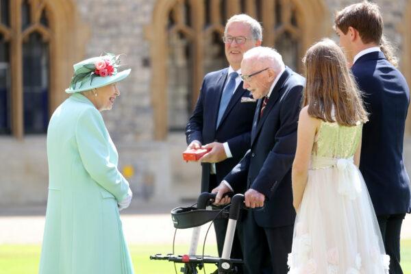Britain's Queen Elizabeth talks to Captain Tom Moore and his family after awarding him with the insignia of Knight Bachelor at Windsor Castle, in Windsor, Britain, on July 17, 2020. (Chris Jackson/Pool via Reuters)