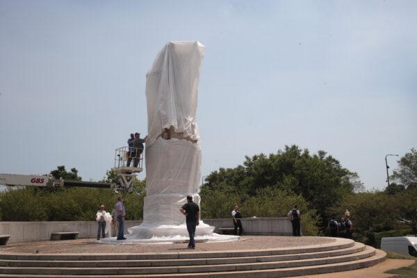 Workers cover a statue of Christopher Columbus before the start of a Juneteenth march in Chicago, Illinois, on June 19, 2020. (Scott Olson/Getty Images)